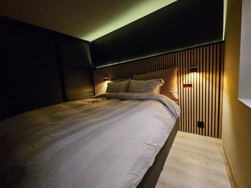a bedroom with a large bed with lights on it at Aurora Central Premium Apartment II, Bodø in Bodø