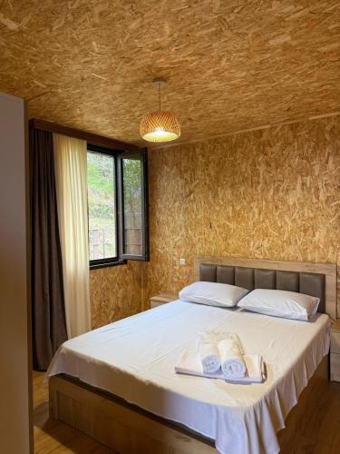 a bedroom with a bed with towels on it at Stillwood Tsikhisdziri in Kobuleti