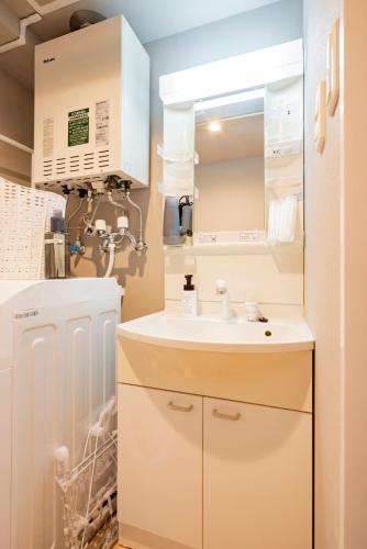 a bathroom with a sink and a refrigerator at La Meridian Atsubetsu 401 in Sapporo