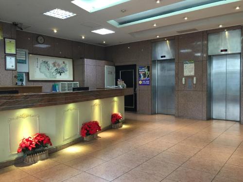 a lobby of a hotel with red flowers on the counter at 奇萊大飯店 Chuline Hotel in Hualien City