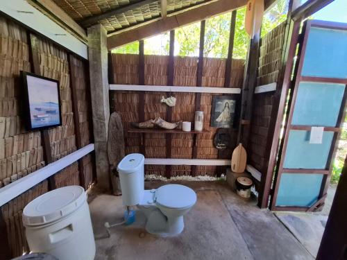 a bathroom with a toilet in a wooden building at BlueWave Surf Stay in San Isidro