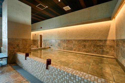 an empty swimming pool in a building with a tile floor at COZY HOTEL NUKUI shimanami in Imabari