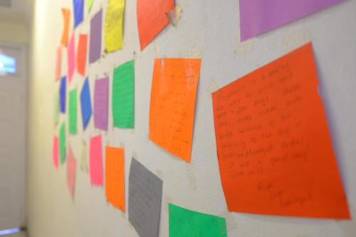 a wall with different colored sheets of paper on it at Bunk Bed and Breakfast in Yogyakarta