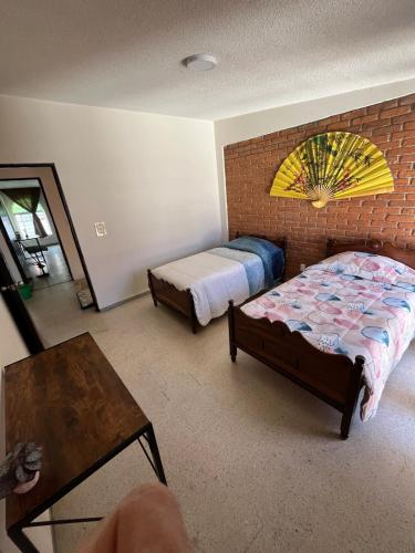 a bedroom with two beds and a brick wall at Rey 179 in Morelia
