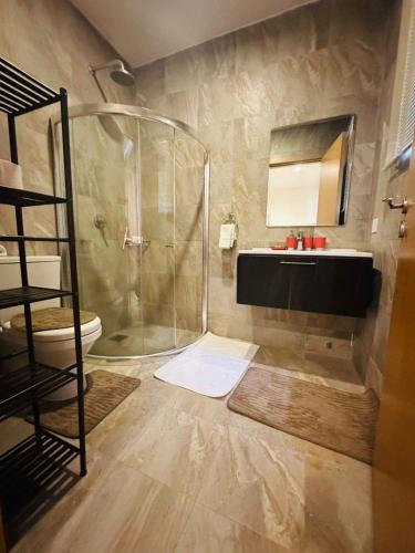 a bathroom with a shower and a toilet and a sink at Luxury & Comfort, with Pool and Ocean Views in Bijilo