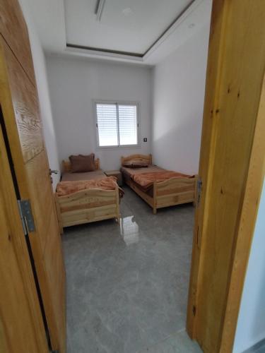 a room with two beds and a window at Djerba Haven Family in Houmt Souk