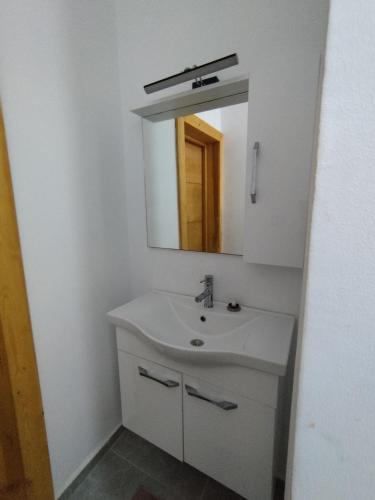 a white bathroom with a sink and a mirror at Djerba Haven Family in Houmt Souk