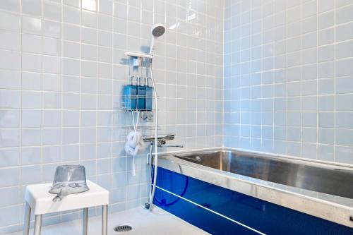 a blue tiled bathroom with a sink and a tub at Tsubaki in Otsu
