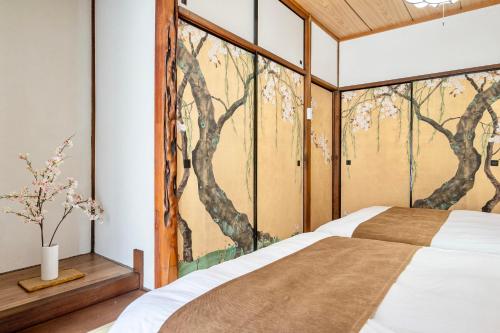 a bedroom with a tree mural on the wall at Tsubaki in Otsu