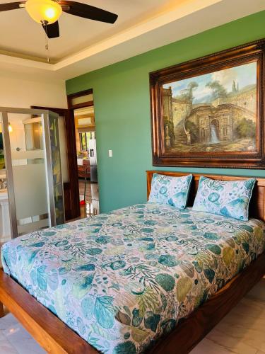 a bedroom with a bed with a painting on the wall at Loma Linda in Arenal