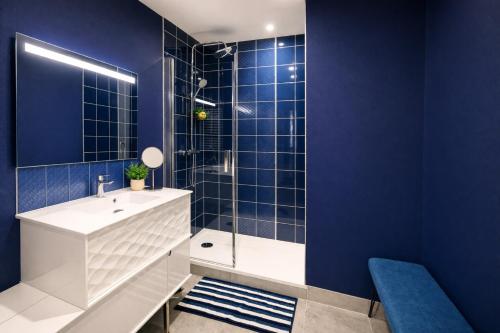 a blue bathroom with a sink and a shower at Le Mans Cosy in Le Mans
