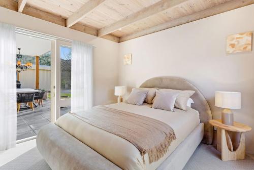 a bedroom with a large bed and a patio at Villa Syrene Pool and Spa Retreat in Rye
