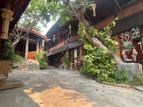 a building with a tree on the side of it at Boutique House Nipha in Chiang Mai