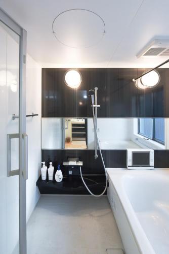 a bathroom with black and white cabinets and a sink at Luxury New House in Tokyo