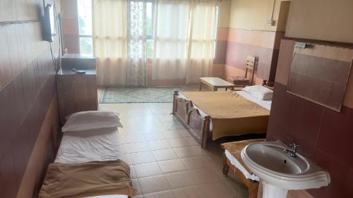 a hospital room with two beds and a sink at Vega tourist lodge in Madikeri