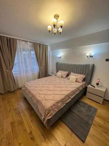 ein Schlafzimmer mit einem großen Bett mit grauem Kopfteil in der Unterkunft Apcentral in Fălticeni
