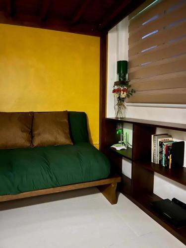 a green couch in a room with a yellow wall at Baler Modern Studio Loft Haven in Baler