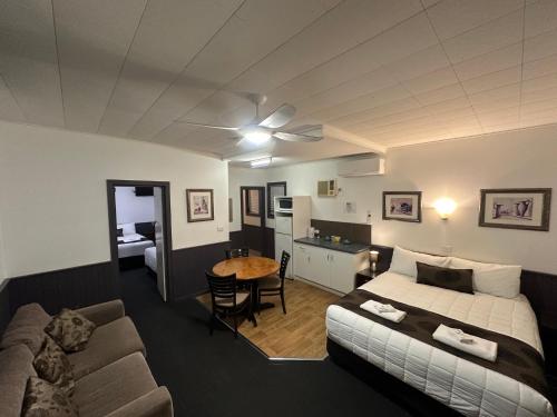 a bedroom with a bed and a couch and a table at The Esplanade Motel in Lakes Entrance