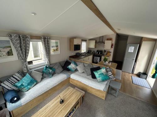 a living room with a couch and a table at Golden Dunes Retreat, Dog-Friendly Stay at Par Sands Holiday Park, Cornwall in Par