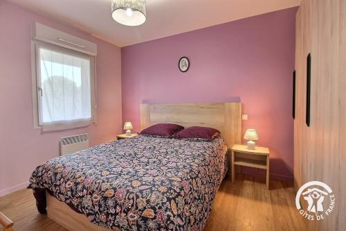 a bedroom with a bed with purple walls and a window at Le randonneur in Pleubian