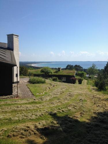 a view of a farm house and the ocean at Architect's House With Panoramic View In Lumsås in Lumsås
