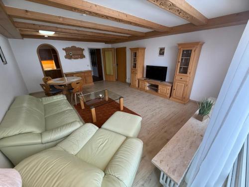 a living room with a white couch and a television at Karwendel Lodge in Mittenwald