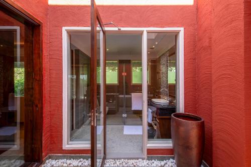 a red building with a glass door and a trash can at Taj Sawai,Ranthambore in Sawāi Mādhopur