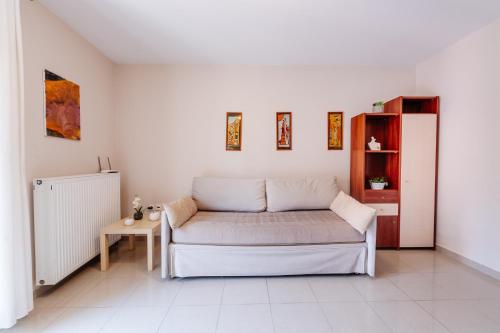 a white living room with a couch and a table at Bella Vista - Historic Centre -4th floor in Corfu