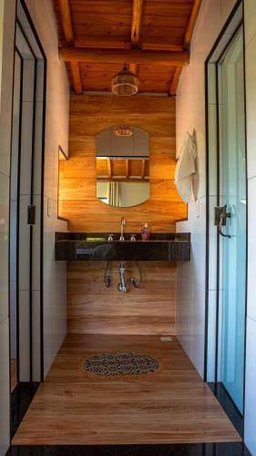 a bathroom with a sink and a mirror at Hospedagem Colinas Chalé 2 in Aiuruoca