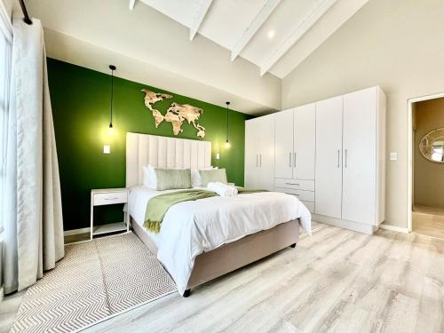 a bedroom with a large bed with a green wall at Rustic Hills #30 in Swakopmund