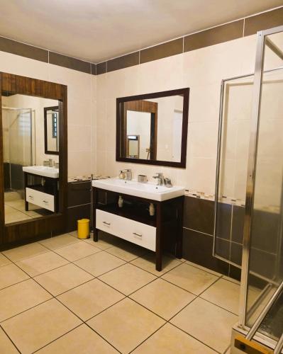 a bathroom with two sinks and two mirrors at Villa Ö Schandél in Saint-Paul