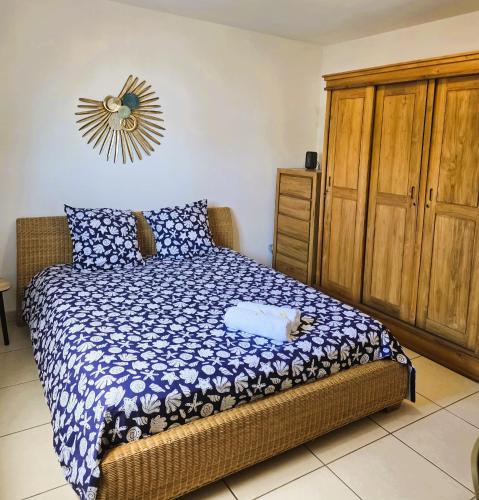 a bedroom with a bed and a wooden cabinet at Villa Ö Schandél in Saint-Paul