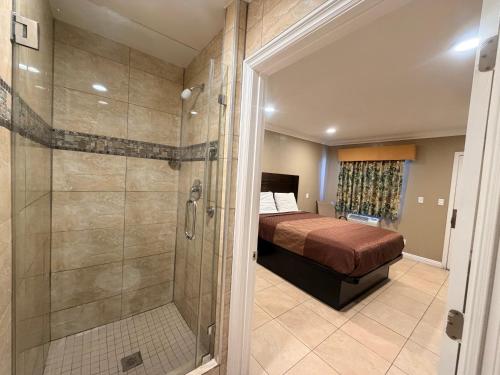 a bedroom with a bed and a glass shower at Stallion Motel Los Angeles in Los Angeles