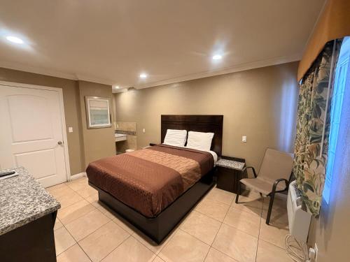 a bedroom with a bed and a chair in it at Stallion Motel Los Angeles in Los Angeles