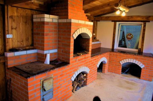 a brick oven in a room with a window at Casa Vanatorului Buzaiel in Vama Buzăului