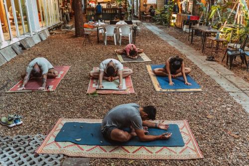 a group of people doing yoga on the ground at The Yard Bangkok Hostel in Bangkok