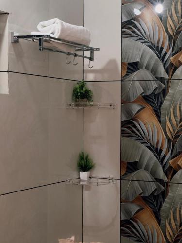 a bathroom with two plants on a wall at VGK Residency in Wayanad