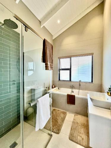 a bathroom with a tub and a sink and a shower at Rustic Hills #30 in Swakopmund