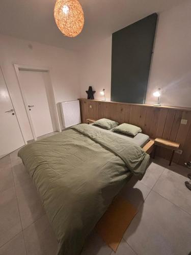 a bedroom with a large bed with a wooden headboard at Bivouac 101 in Bastogne