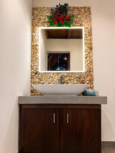 a bathroom with a sink and a mirror at Coffee Cabanas in Matale
