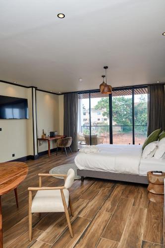 a large bedroom with a large bed and a table at KÓLÒ Hôtel in Yaoundé