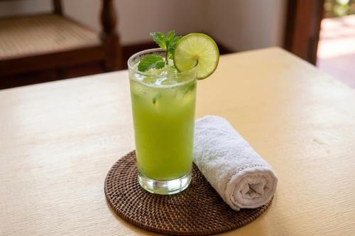 a drink on a coaster with a slice of lime at Tree Avenue Villa Dambulla in Galewela