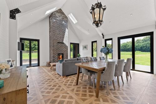 a dining room with a table and a fireplace at The Mist, Luxury Farm w Fireplace & Hot tub in Exeter