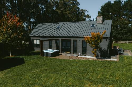 a small house with a tub in a yard at The Mist, Luxury Farm w Fireplace & Hot tub in Exeter