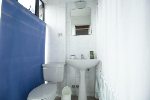 a bathroom with a white toilet and a sink at Amplia casa en Reñaca para 10 personas in Viña del Mar