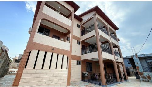 a tall building with a balcony in front of it at Ragant Hotel in Kwapro