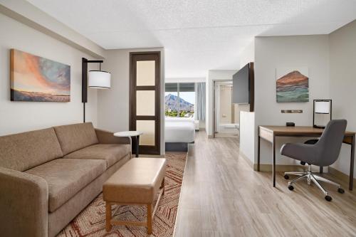 a living room with a couch and a desk and a bedroom at Hyatt Place Scottsdale/Old Town in Scottsdale