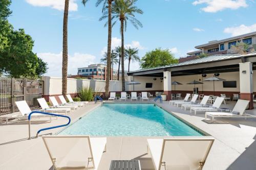 a swimming pool with lounge chairs and a resort at Hyatt Place Scottsdale/Old Town in Scottsdale