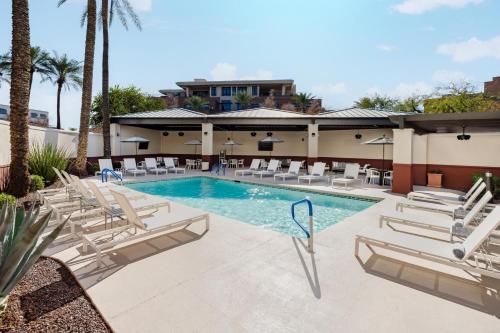 a swimming pool with lounge chairs and a resort at Hyatt Place Scottsdale/Old Town in Scottsdale