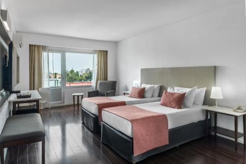 a hotel room with two beds and a television at Dazzler by Wyndham Buenos Aires Recoleta in Buenos Aires